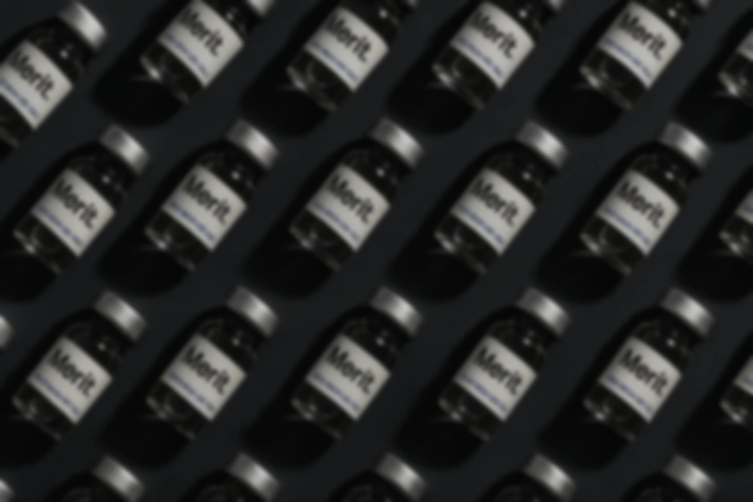 A defocused wall of sealed Merit Sciences research compound vials in repeating rows
